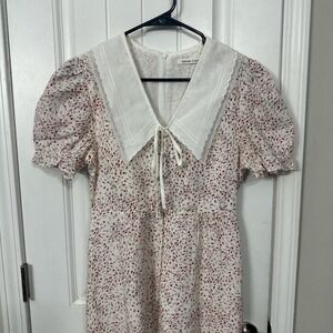 Delicate floral print, short puff sleeves, and distinctive large white collar. L